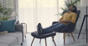 man sitting on chair wearing headphones